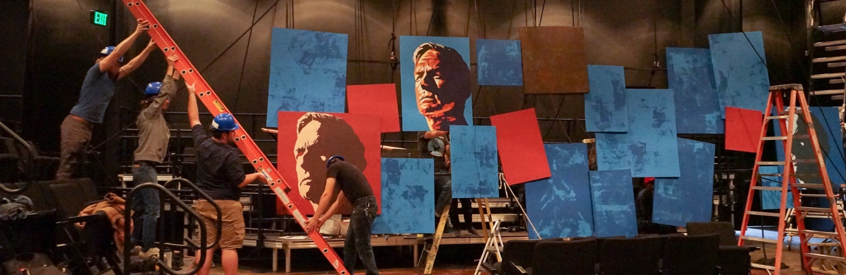 A crew of four setting up props/scenery for Julius Caesar