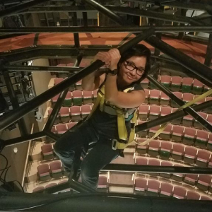 Tech student hanging from the lighting grid in the Marian Theatre
