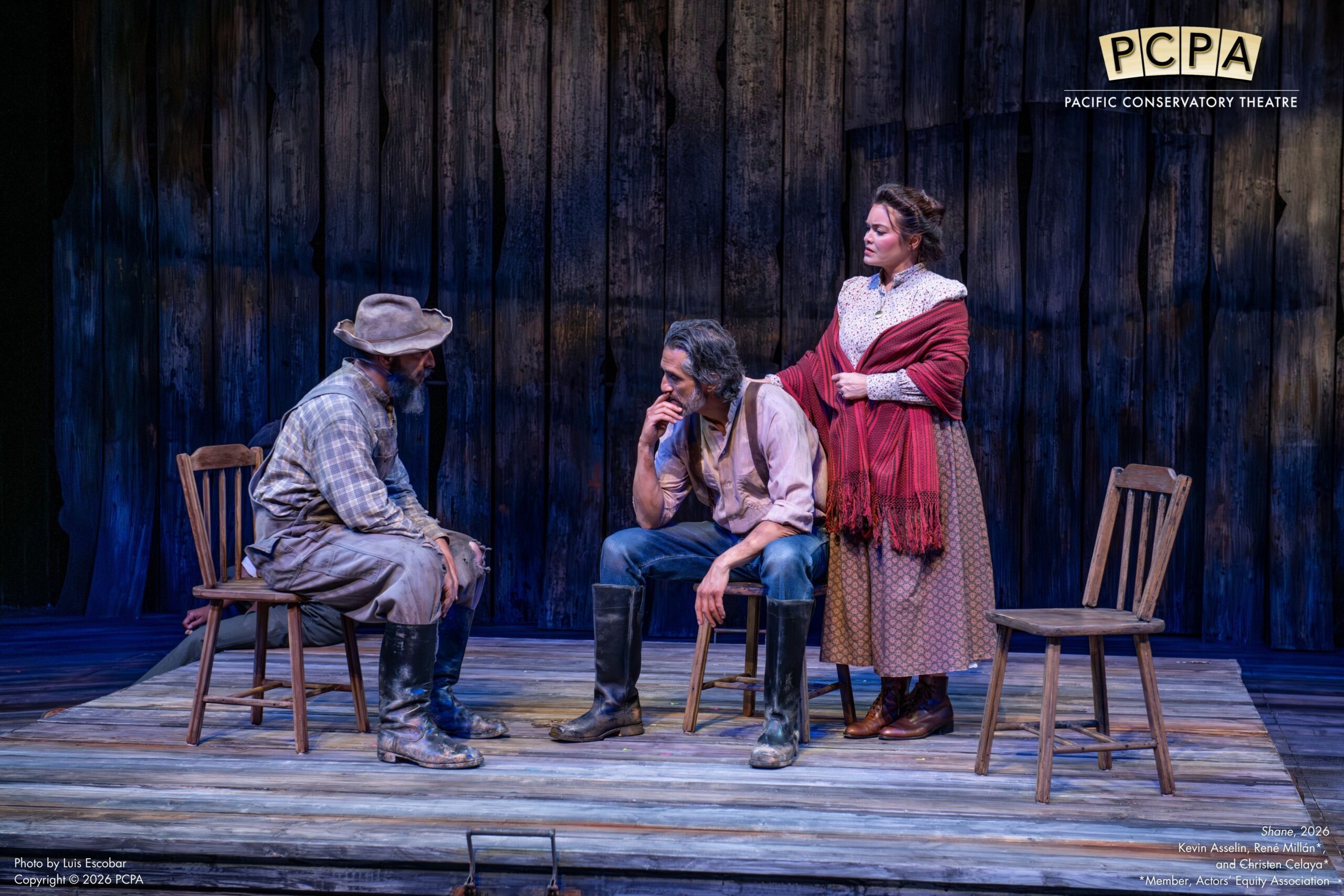 Actors on stage sitting on chairs