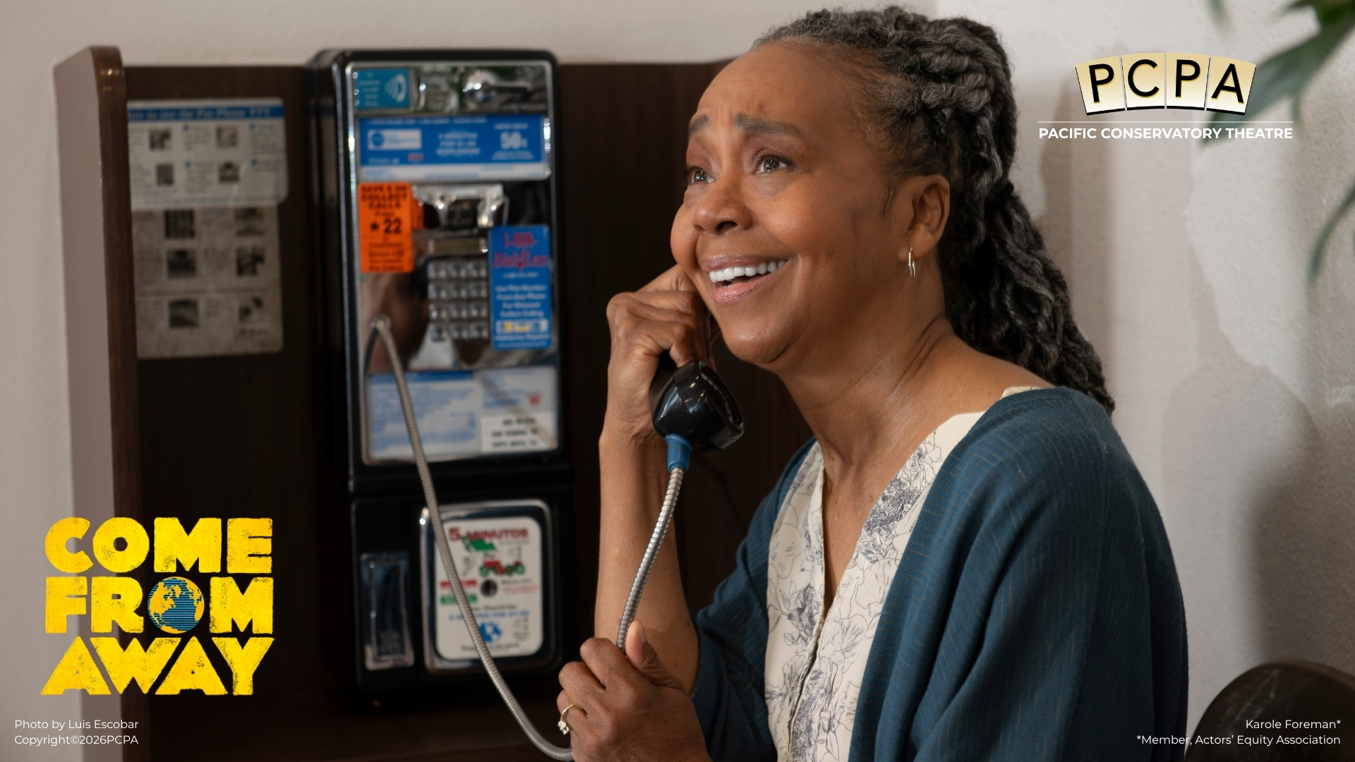 Actor holding pay phone looking up